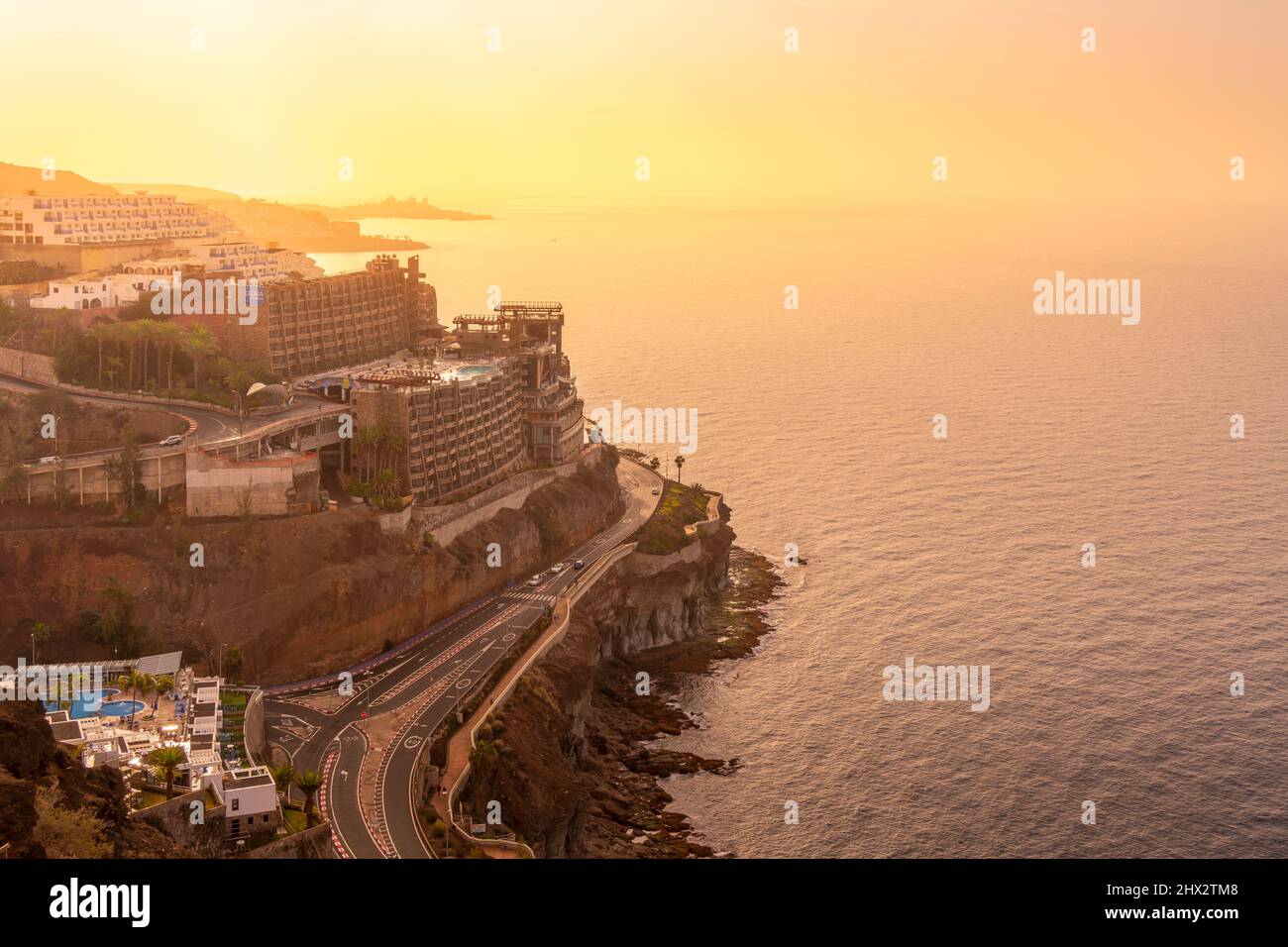 View of coastal road and hotels near Puerto Rico at sunsrise, Playa de Puerto Rico, Gran Canaria, Canary Islands, Spain, Europe Stock Photo