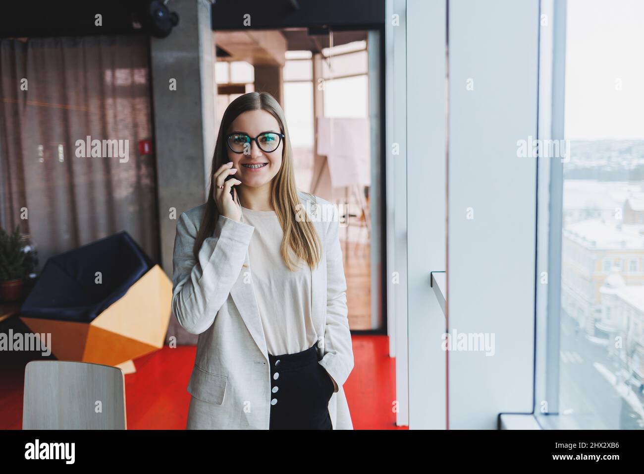 Young charming woman calling with a cell phone while sitting alone in a ...