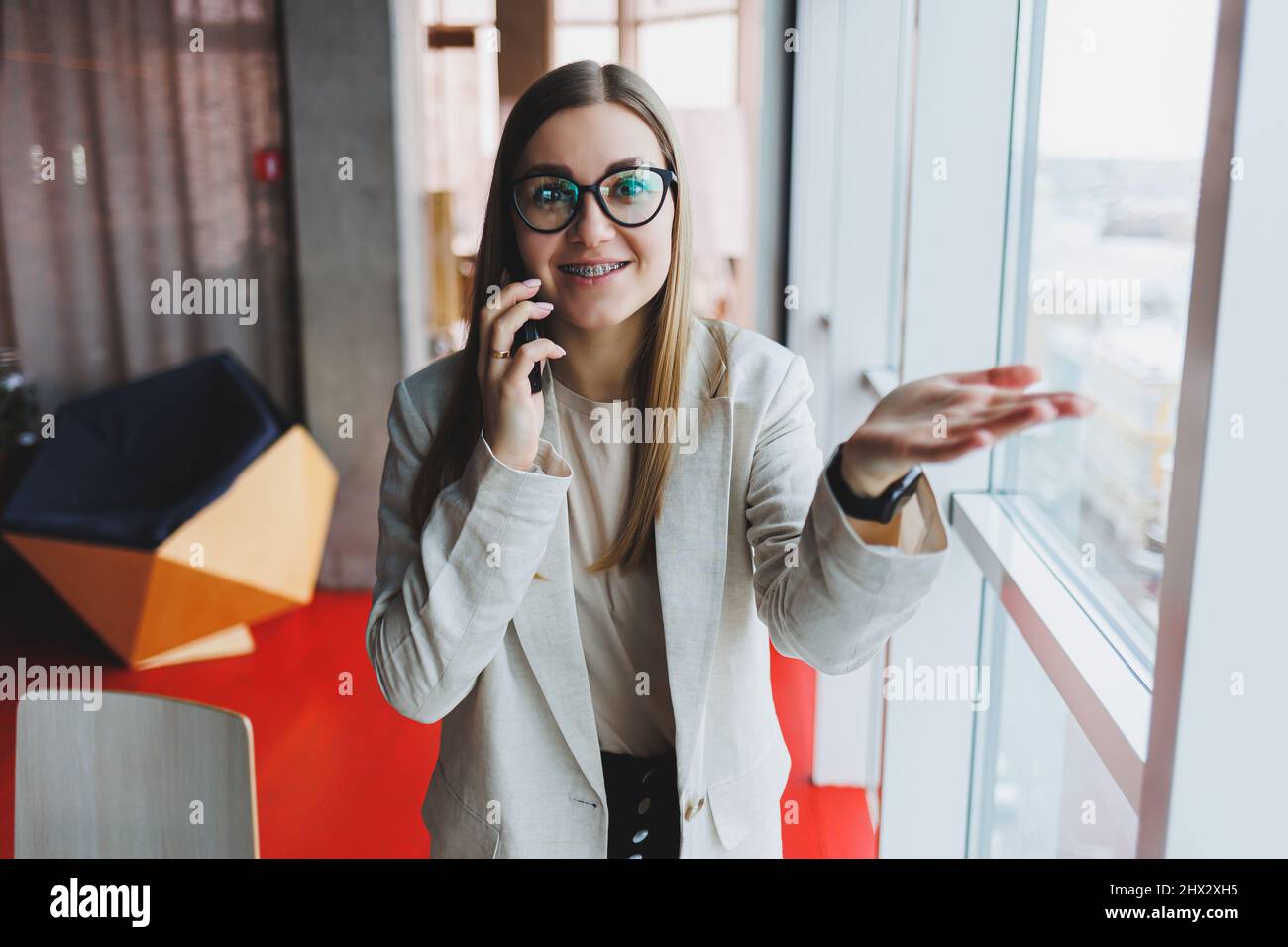 Young charming woman calling with a cell phone while sitting alone in a ...