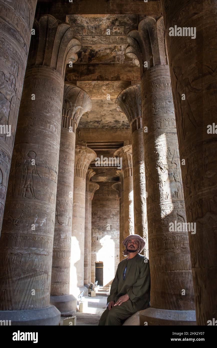 Guard sitting against a column in the large hypostyle room, Temple of Edfu, Egypt, Northern Africa. Stock Photo