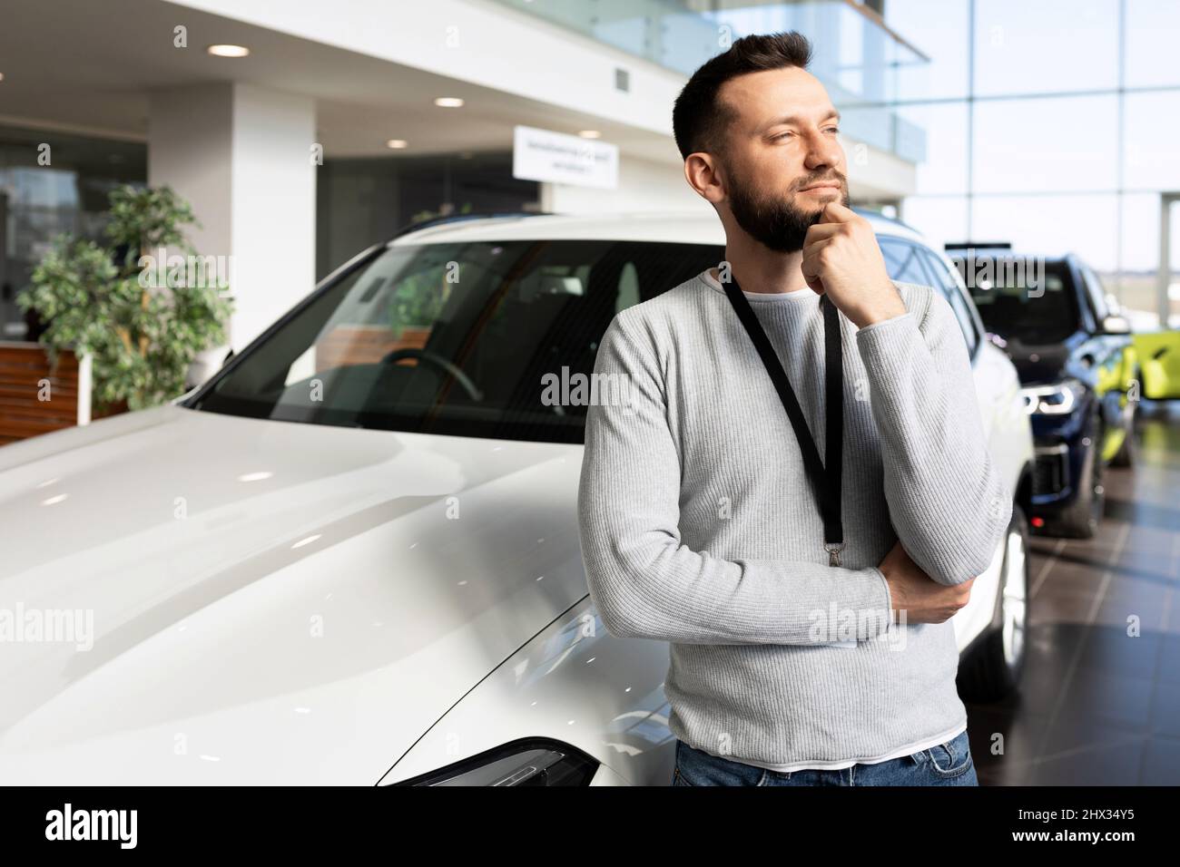 car sales manager at car dealership looking ahead thoughtfully Stock