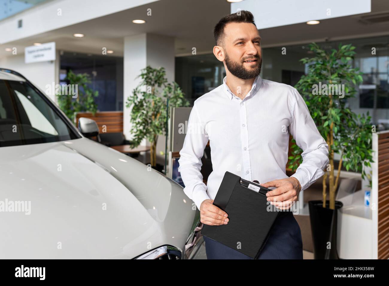 Sales Manager In A Car Dealership Hands Over The Keys And Documents To 