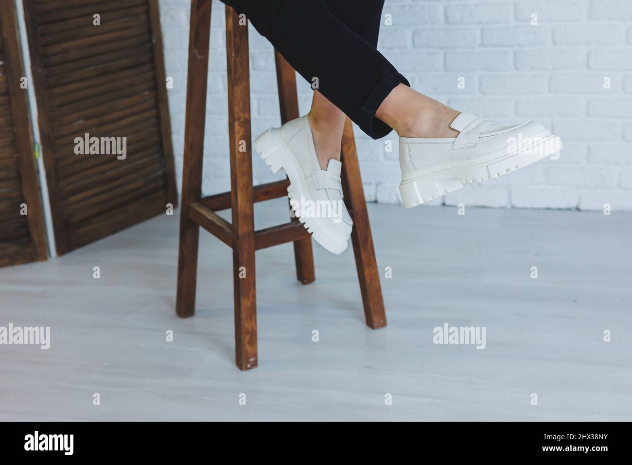 Legs of a young beautiful woman in black trousers and modern stylish