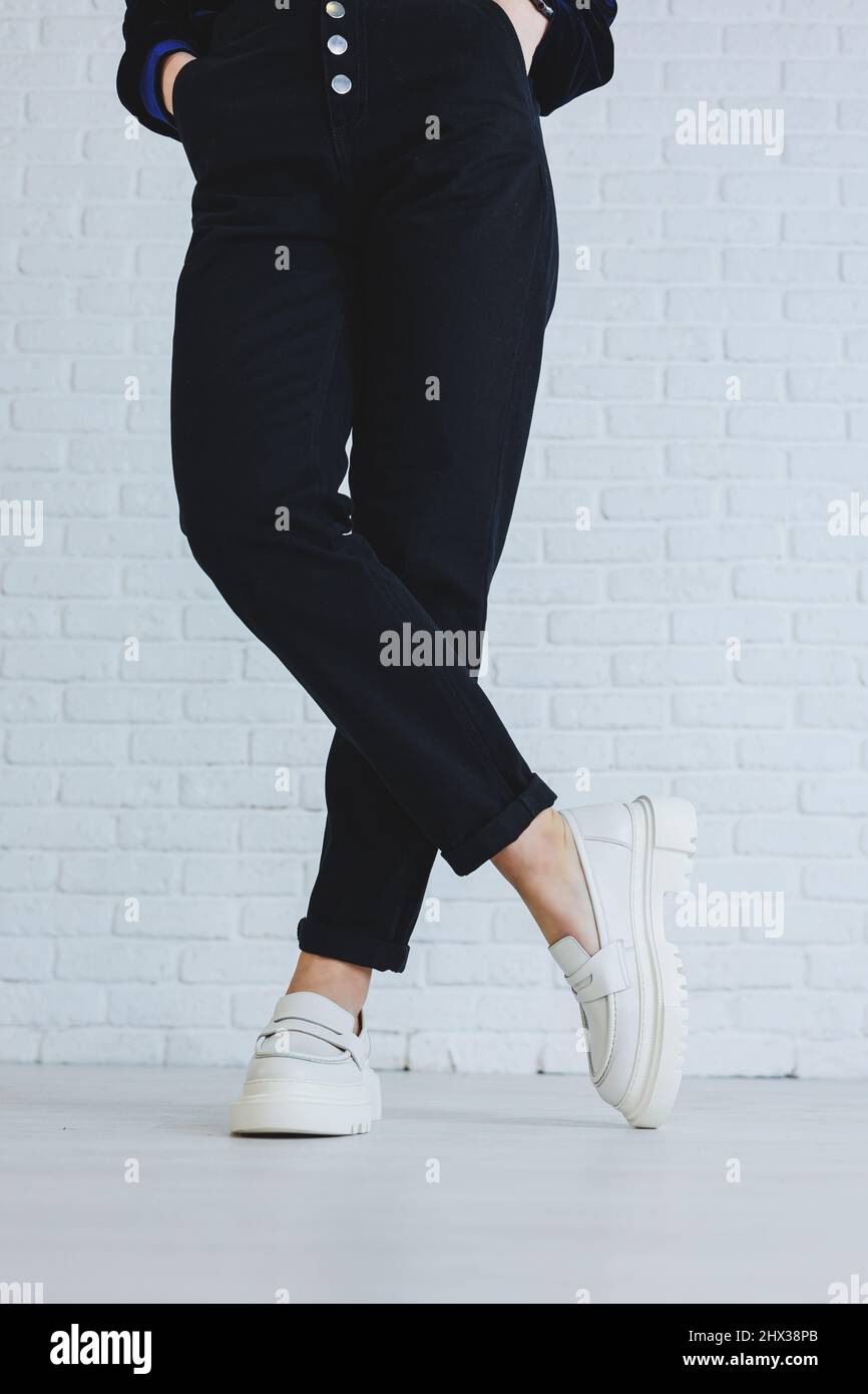 Legs of a young beautiful woman in black trousers and modern stylish