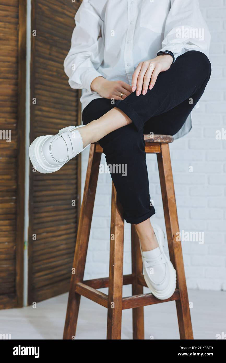Legs of a young beautiful woman in black trousers and modern stylish