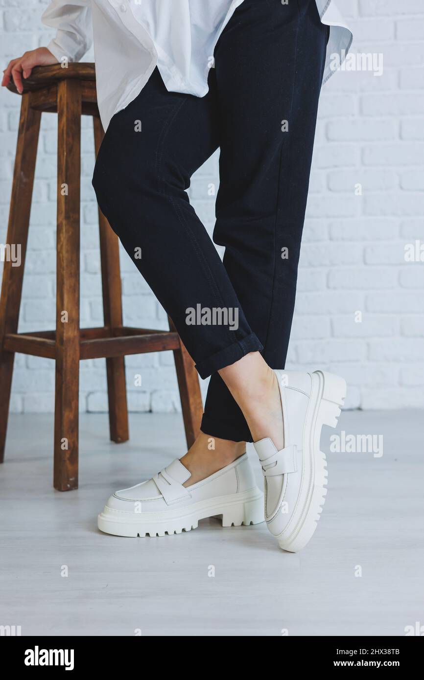 Legs of a young beautiful woman in black trousers and modern stylish