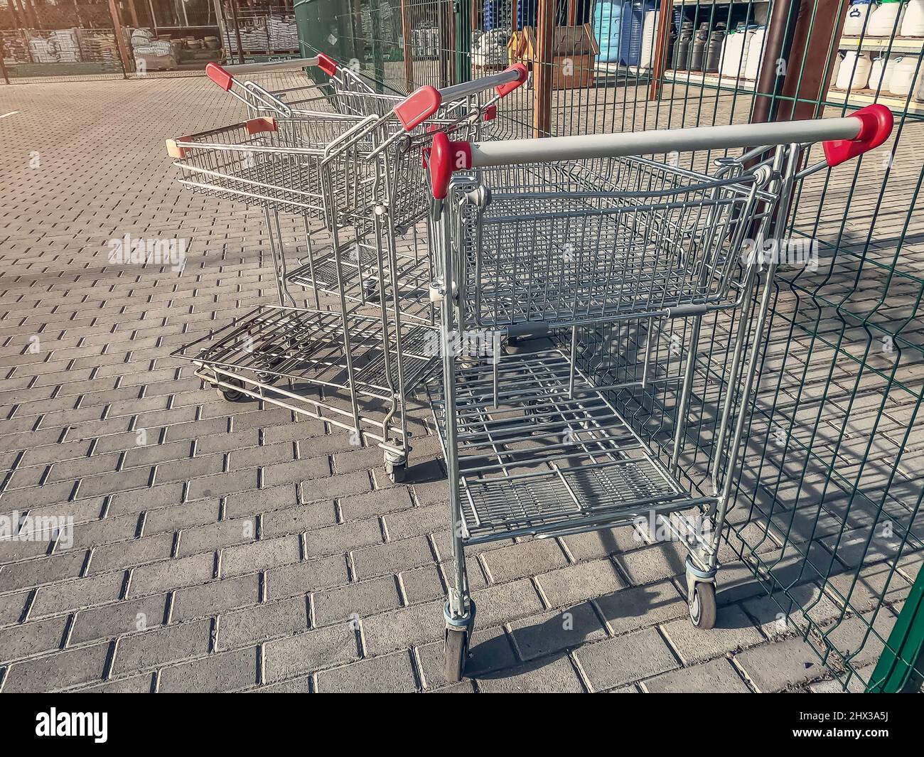 Steel shopping carts in supermarket. Used carts on pavement Stock Photo