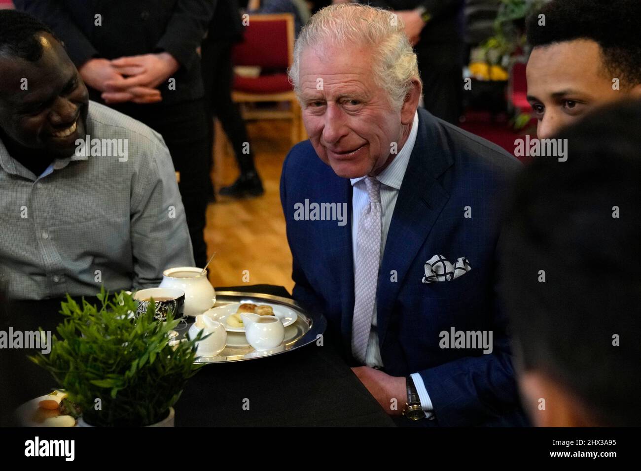 The Prince of Wales (centre) meets refugees at the community cafe during a visit to St Luke's Church, Earl's Court, west London, to learn about the work of Holy Trinity Brompton in supporting refugees and asylum seekers. Picture date: Wednesday March 9, 2022. Stock Photo