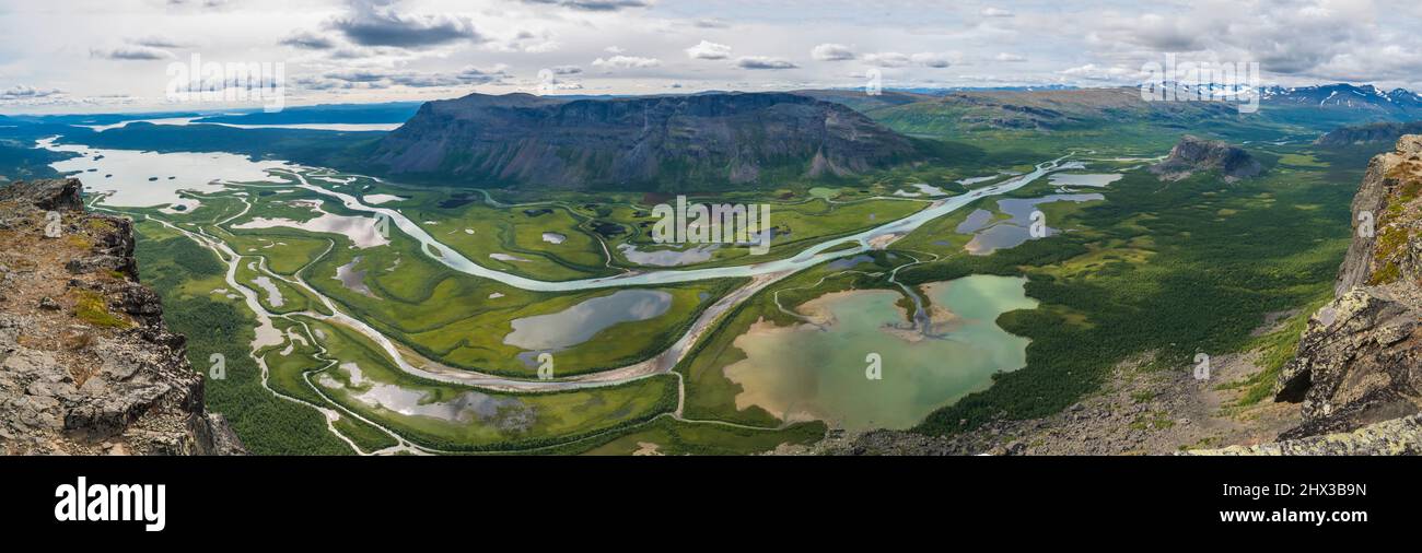 Aerial panoramic scenic view from Skierffe rock summit on glacial Rapadalen river delta valley at Sarek national park with meanders, lakes, mountains Stock Photo