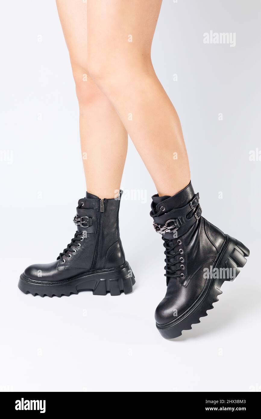 Legs of a woman in black leather boots from a new collection on a white  background, legs of a girl in fashionable leather boots spring 2022 Stock  Photo - Alamy