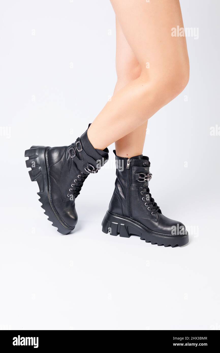 Legs of a woman in black leather boots from a new collection on a white  background, legs of a girl in fashionable leather boots spring 2022 Stock  Photo - Alamy