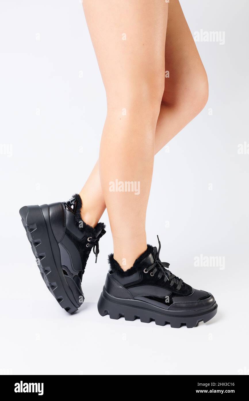 Belangrijk nieuws pad Graveren Fashionable black sneakers on the legs of a woman in the studio on a white  background. Legs of a young girl with beautiful trendy shoes Stock Photo -  Alamy