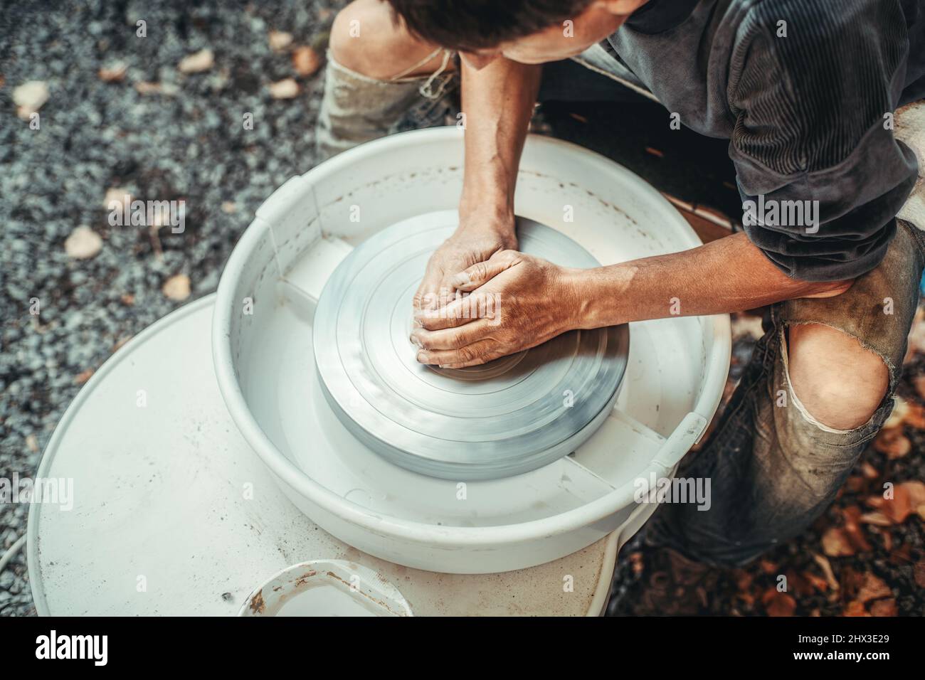 Potter wheel and potter hands, skilled hands of potter shaping the clay