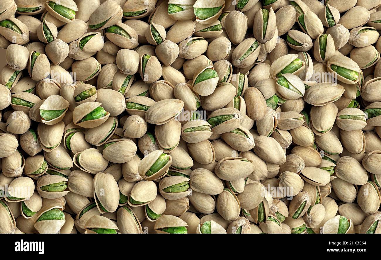 Pistachio seed background as a bulk group of naturally opened seeds representing a healthy snack and nutritious source of protein. Stock Photo