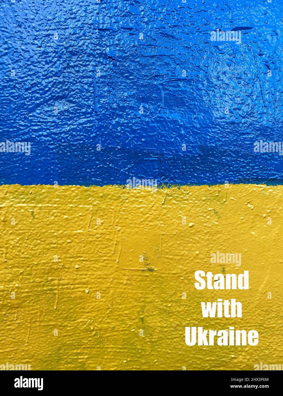 Stand with Ukraine losung on wall painted as Ukrainian national flag Stock Photo