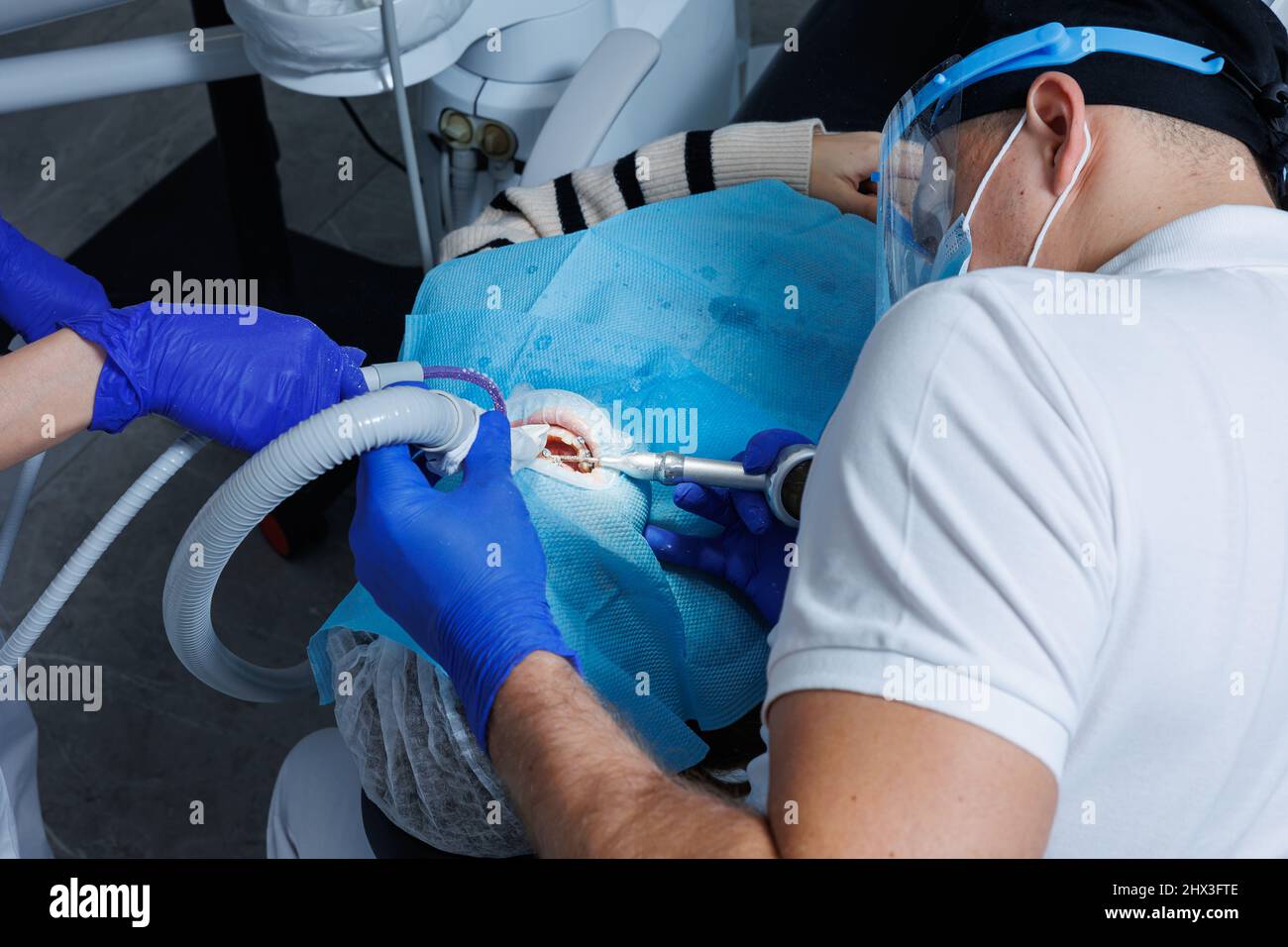 A professional dentist examines a patient's teeth with dental equipment ...