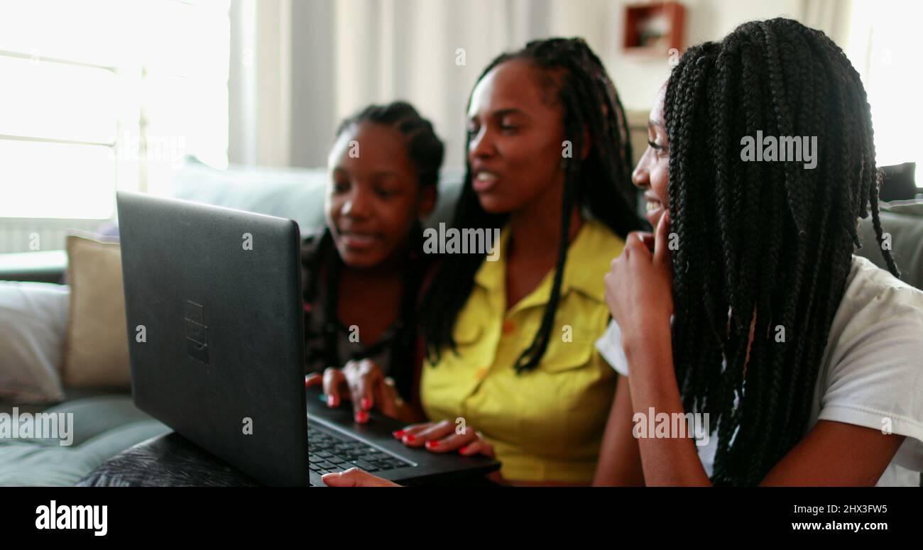 African mother speaking with family member with laptop long-distance ...
