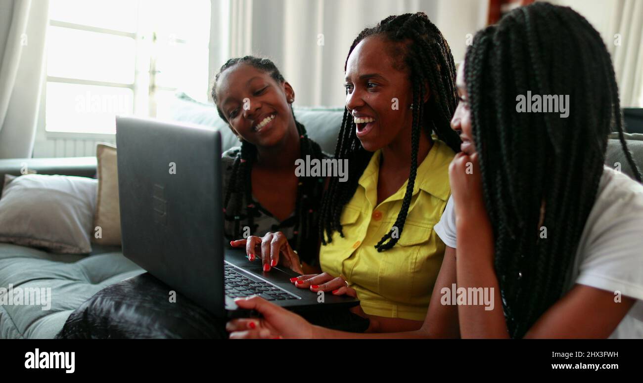 African mother speaking with family member with laptop long-distance ...