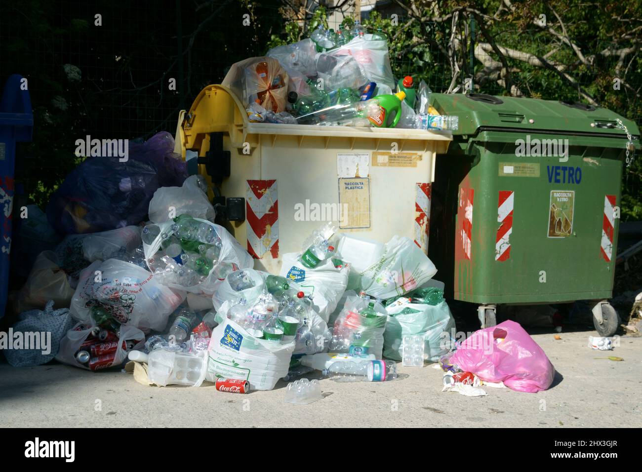 Municipal bins with plastic and aluminum waste overflowing with