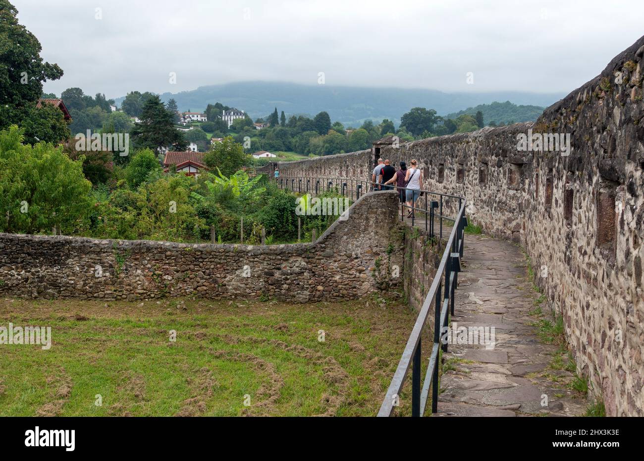Tourists walking the old town walls of St Jean Pied de Port in France Stock Photo