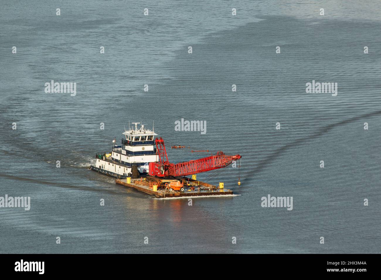 Tug Boat on the Ohio River. The barge is carrying a crane and other equipment. As viewed from Mount Echo Park. Cincinnati, Ohio, USA. Stock Photo