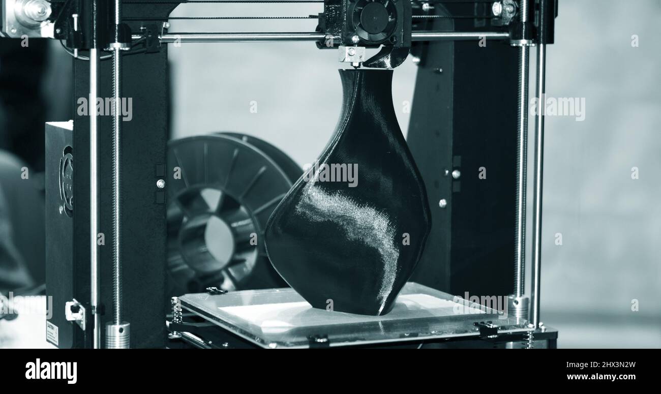 3D printer printing a model in the form of black vase close-up Stock Photo