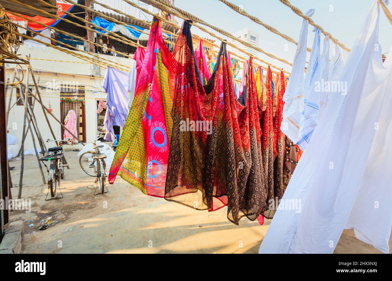 Colourful saris and white sheets hanging out to dry, drying in the sun in Mahalaxmi Dhobi Ghat, a large open air laundromat in Mumbai, India Stock Photo
