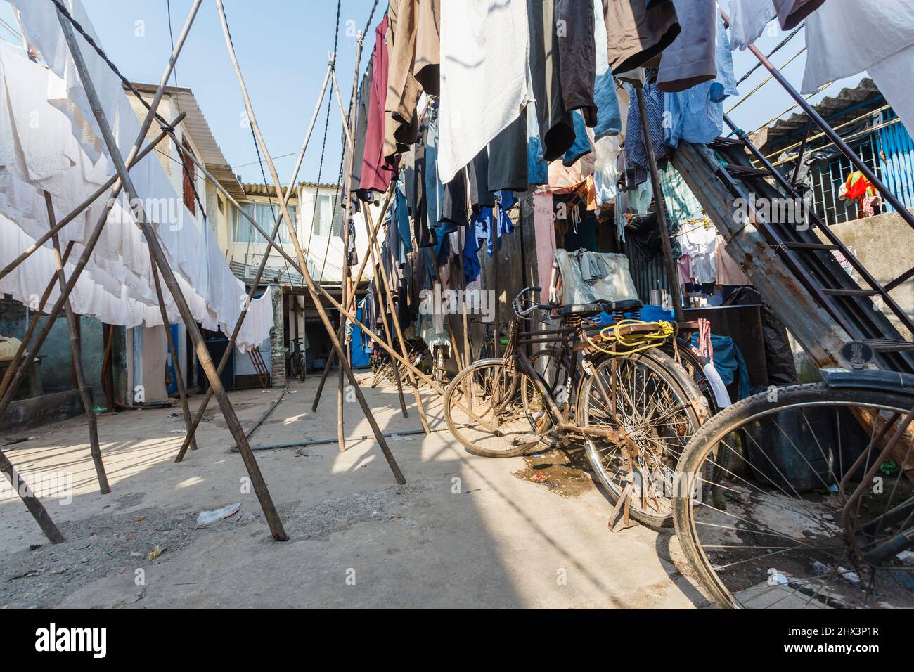 Bicycles with clean fresh clothes and towels hanging out to dry in the open air in Mahalaxmi Dhobi Ghat, a large open air laundromat in Mumbai, India Stock Photo