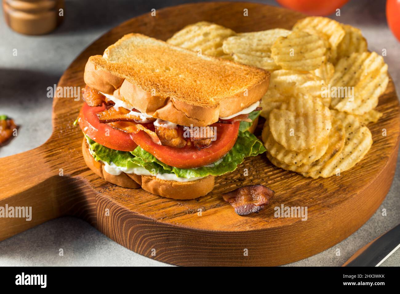 Homemade Bacon Lettuce Tomato BLT Sandwich with Potato Chips Stock