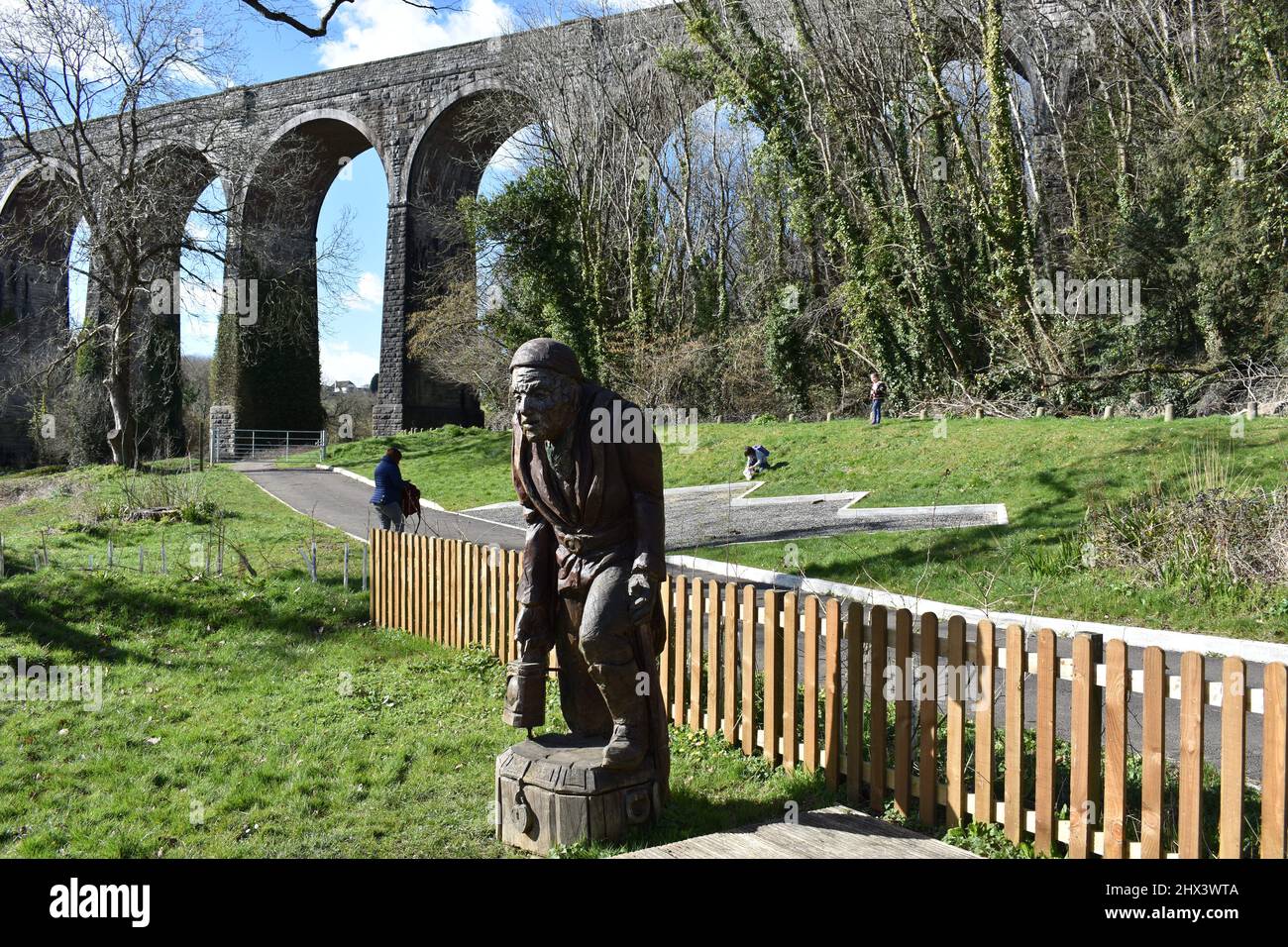 Carved wooden sculpture in front of the railway viaduct, Porthkerry country park, Barry, Glamorgan, Wales Stock Photo