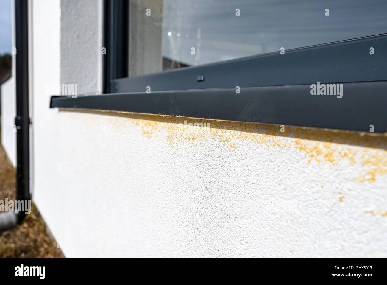 Yellow mounting foam filled under the window sill, white plaster is stained by sloppy work. Stock Photo