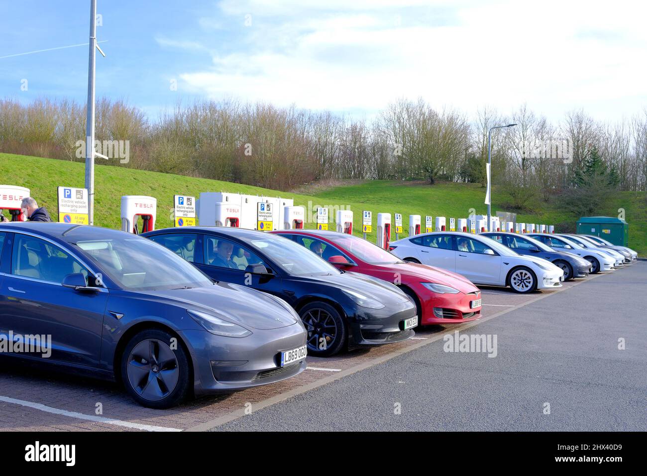 Oxford, UK. 9th March 2022.A line of Tesla electric cars being recharged at Oxford Services off the M40, their owners taking advantage of cheaper motoring costs. Credit: Simon Morley/Almay Live News Stock Photo