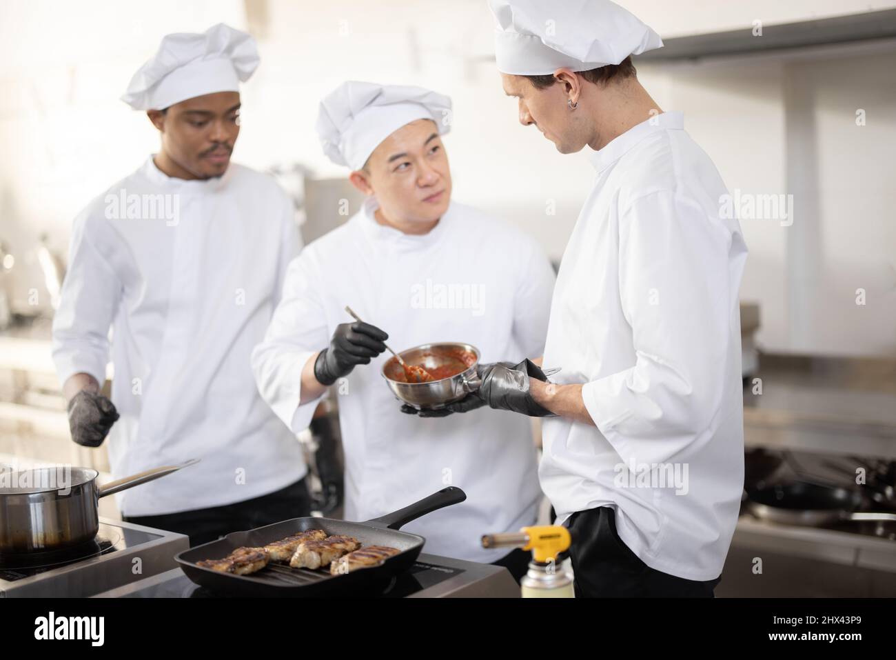 Chef cook tasting food with wooden spoon at the restaurant kitchen Stock  Photo - Alamy