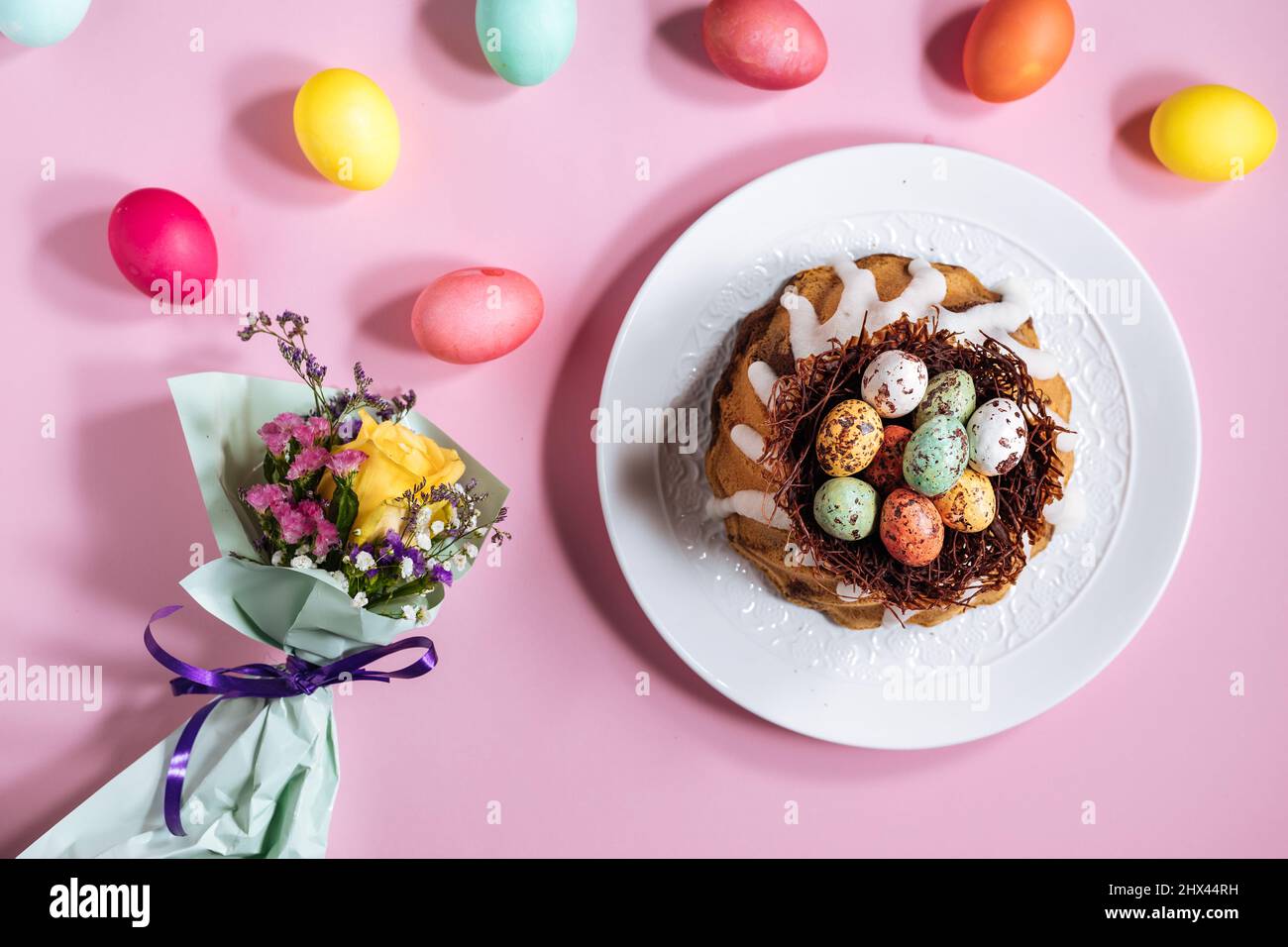 Easter cake top view on pink background. With colorful eggs placed in chocolate nest on top Stock Photo