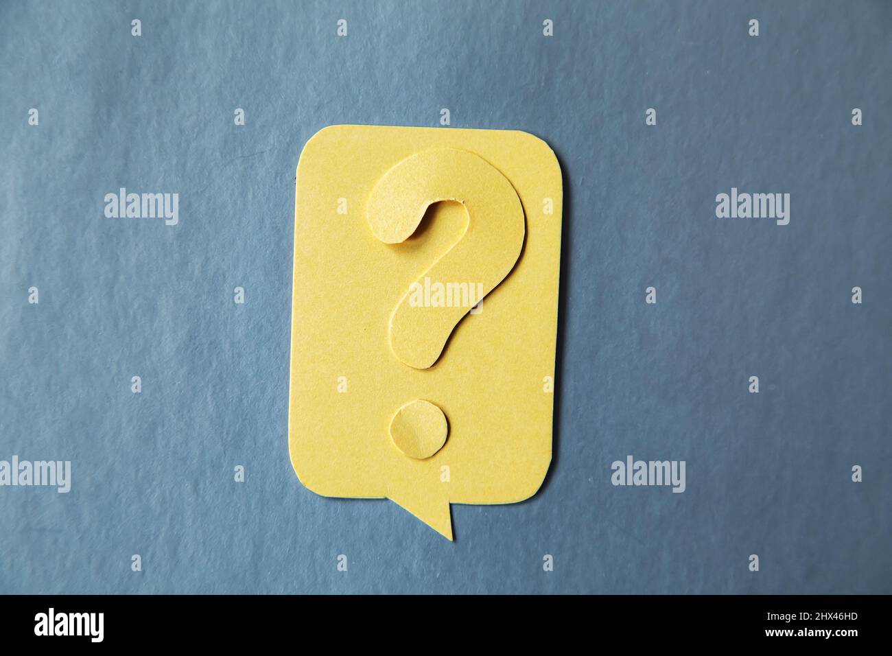 Question mark on yellow speech bubble, gray background. Problem and solution concept. Brainstorm. Stock Photo