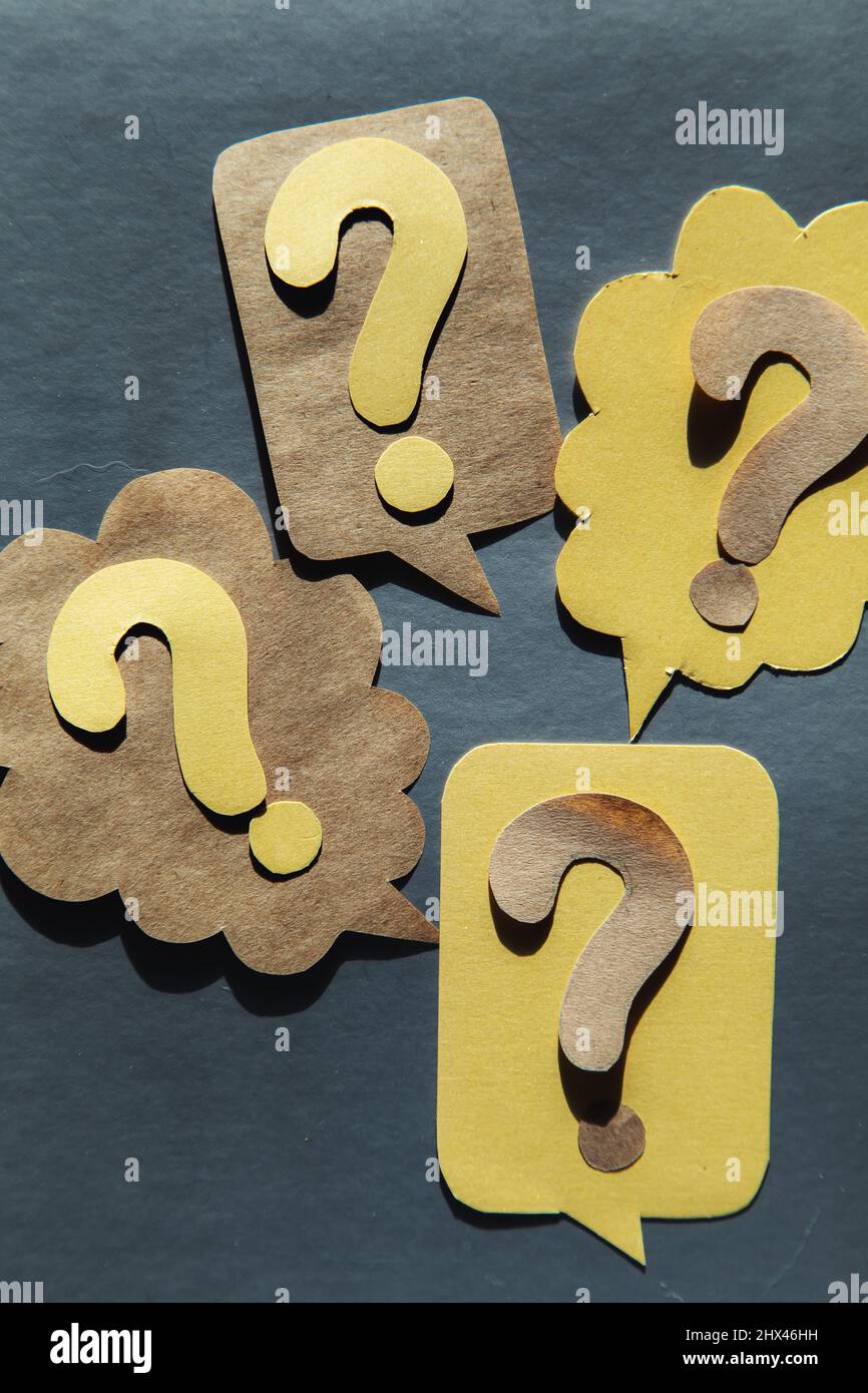 Question mark on speech bubbles, gray background. View from above. Problem and solution concept. Brainstorm. Stock Photo