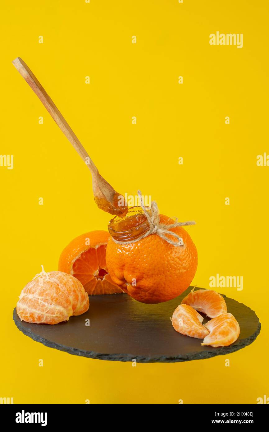 Mandarin orange jam in a little orange jar, with mandarin wedges Stock