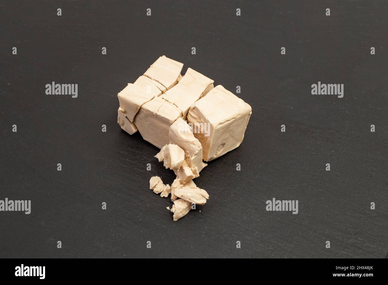 Fragmented cube of yeast isolated on black background Stock Photo