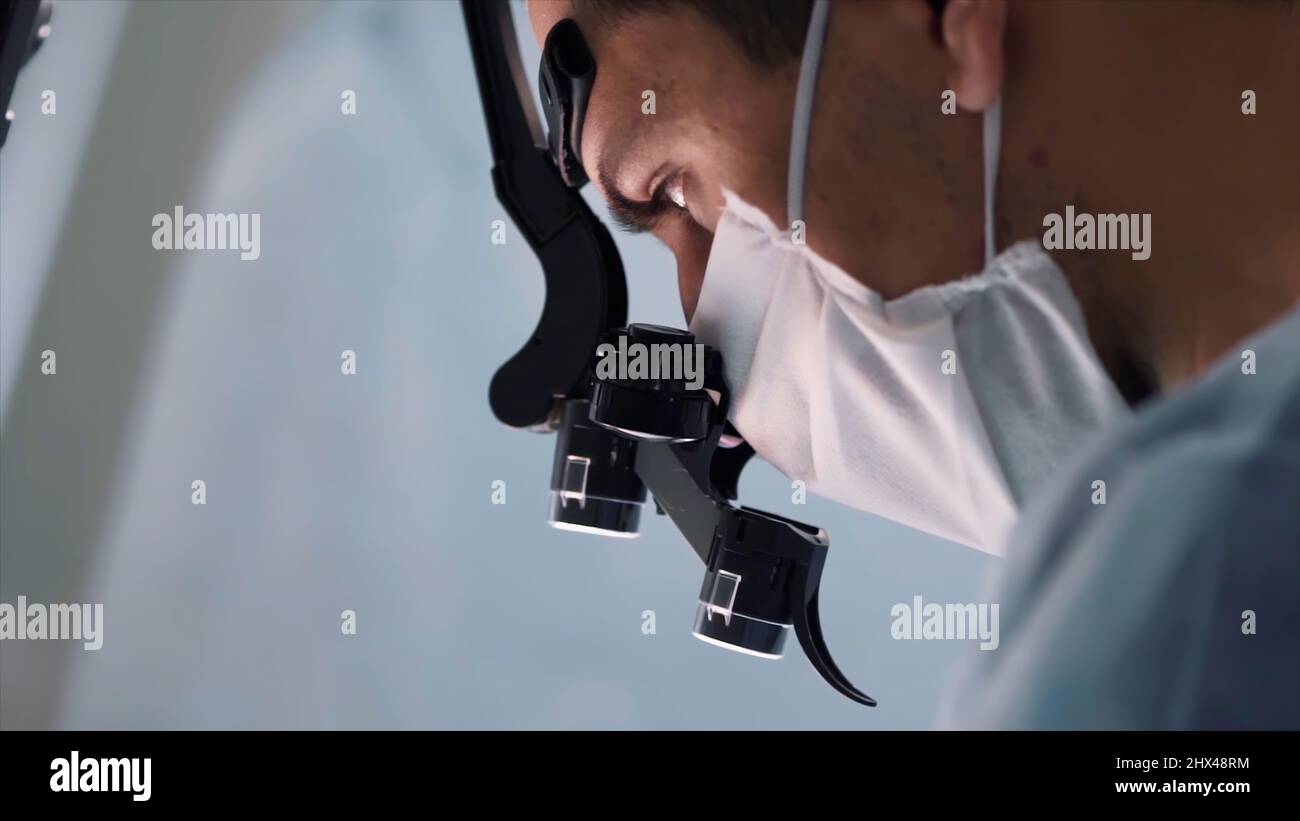 Close up of doctor face with surgical loupe, sterile mask and ...