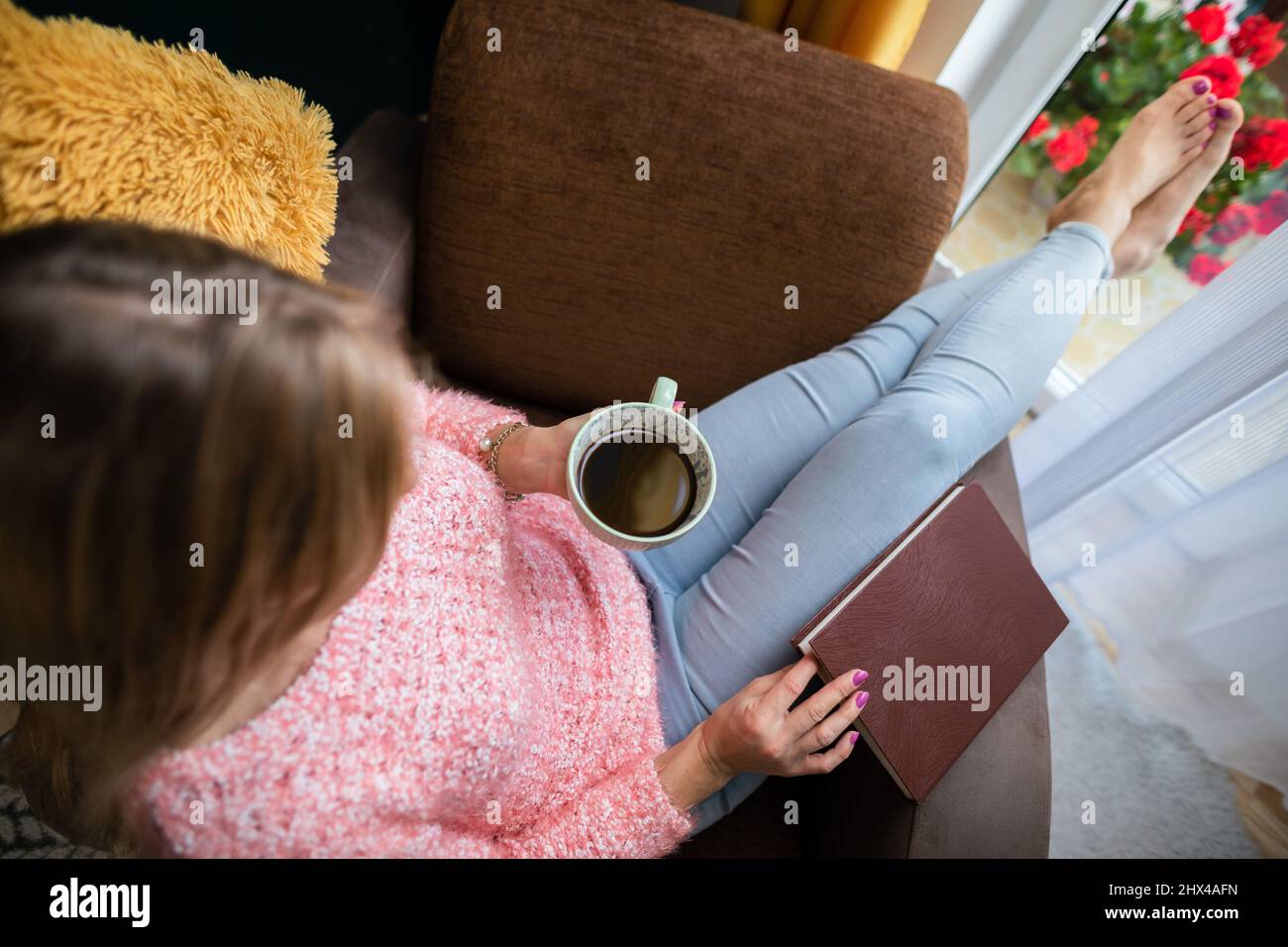 View from above as a girl holds a cup of coffee. Stock Photo