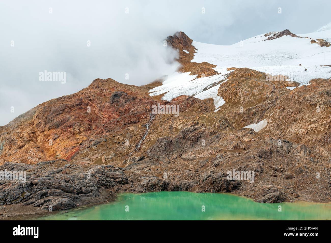 Laguna Verde or green lagoon at 4700m altitude along the hike to the peak of the Cayambe volcano, Cayambe Coca national park, Ecuador. Stock Photo