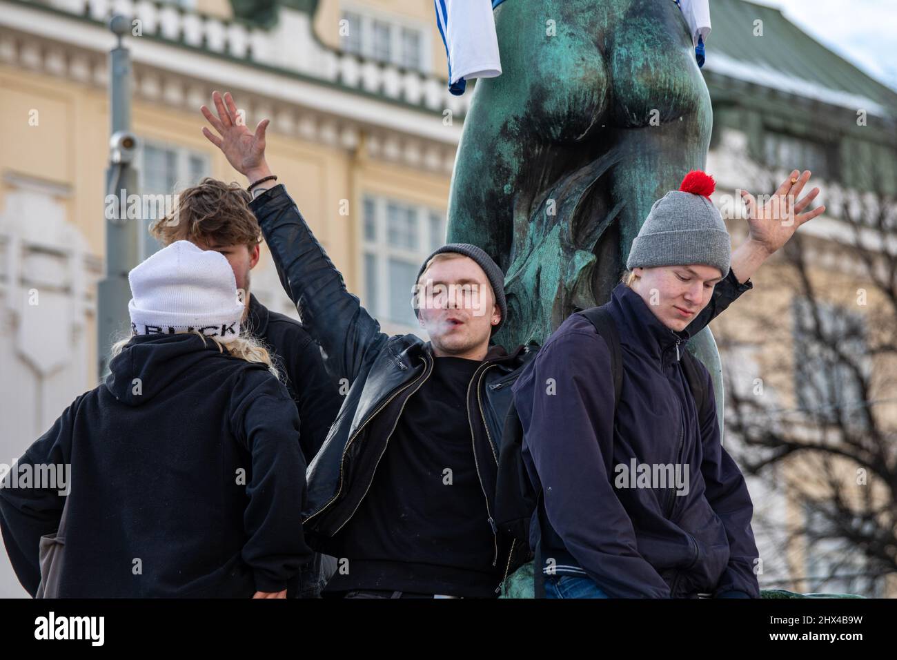 Young people celebrating Olympic men's ice hockey gold medal on Havis Amanda sculpture in Helsinki, Finland Stock Photo