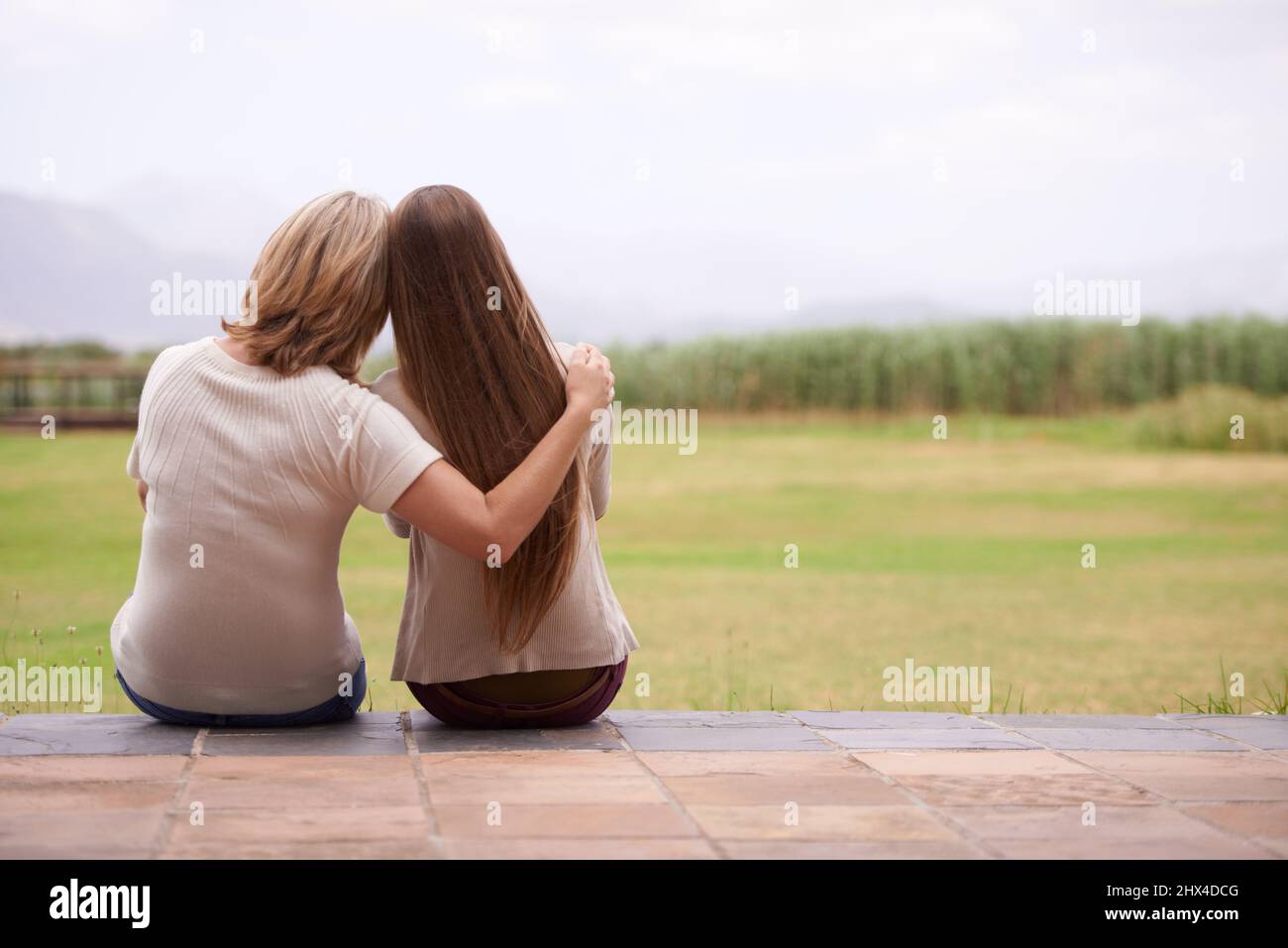 These moments together are so precious. An affectionate mother sitting outside with her adult daughter. Stock Photo