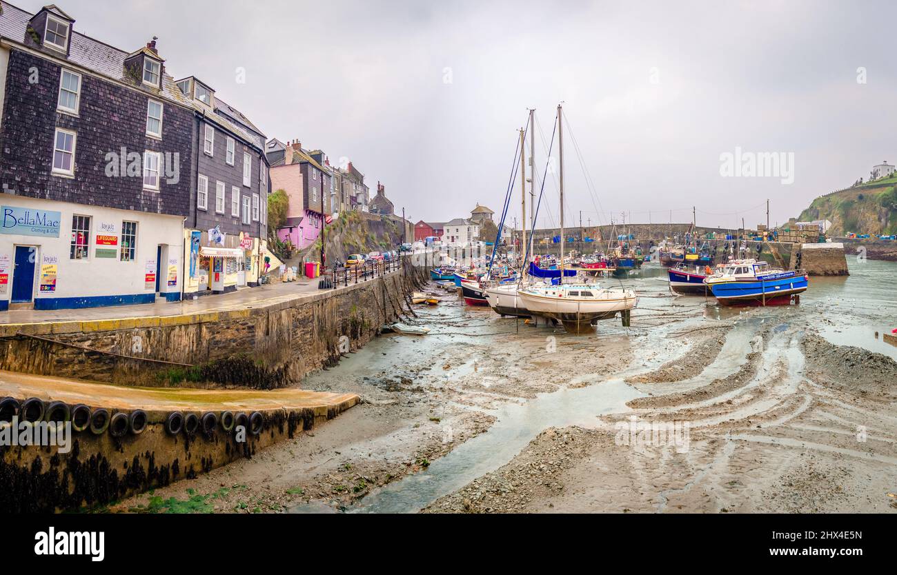 Mavagissey, UK - April 20 2014: View of the waterfront and the Inner Harbour, with lot of fishing boats. Low tide, rainy day. Stock Photo