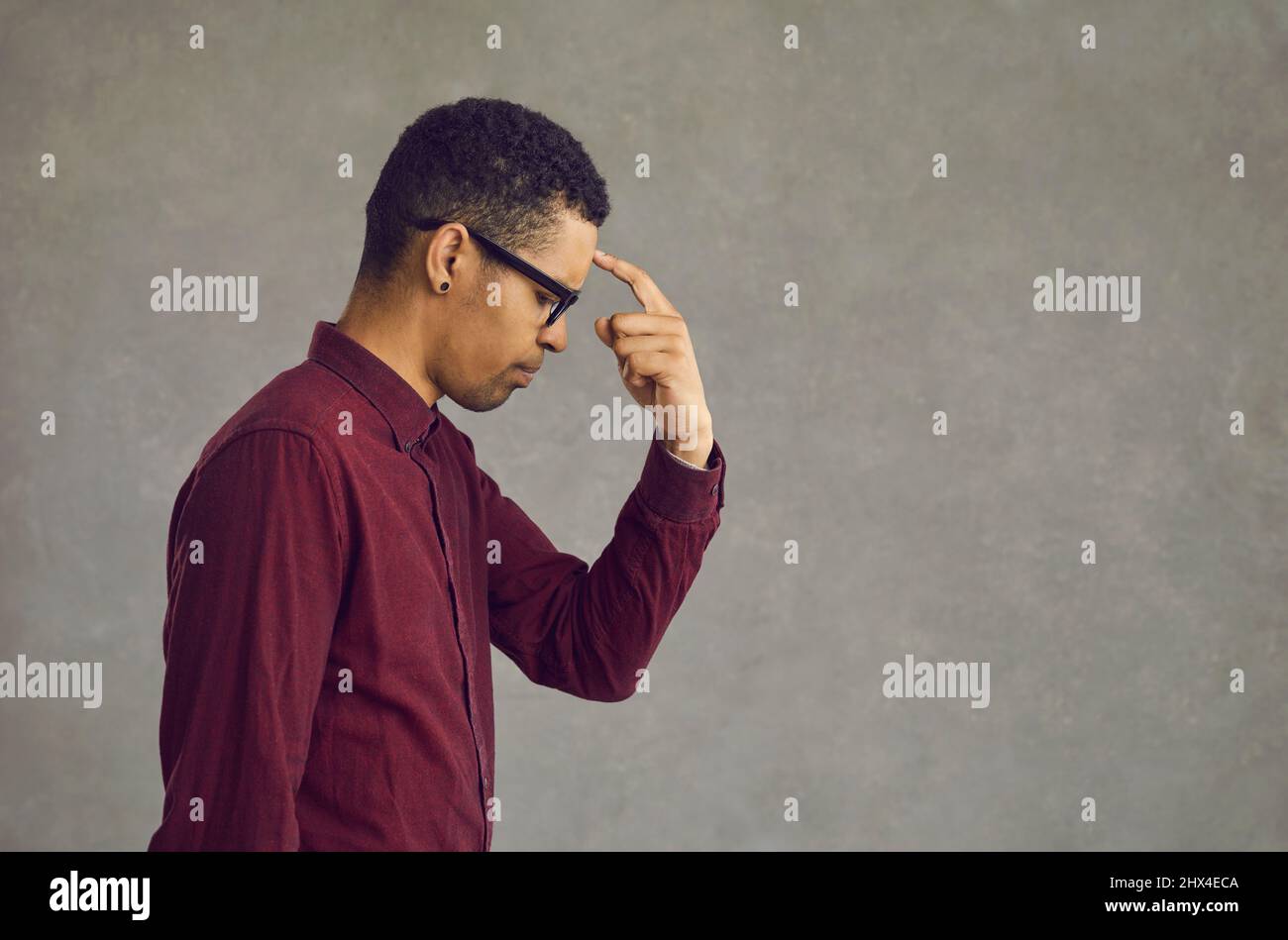 Young african american man thinking put finger to forehead studio portrait Stock Photo