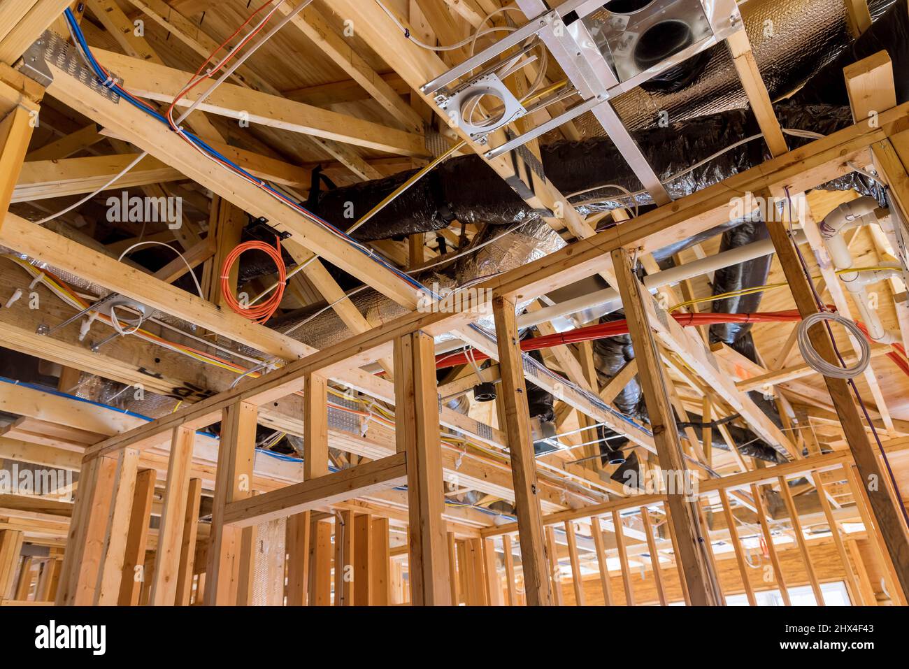 Installation of HVAC tubing vents heating system on the roof, under construction amongst wooden