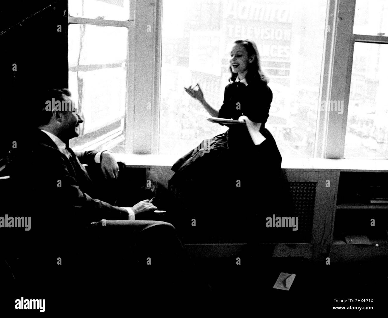 Producer Robert Whitehead smiles his appreciation as Susan reads him a trial script. Although she concentrates hard, she looks relaxed and happy. She likes corny serials. July 8, 1955. (Photo by Look Magazine). Stock Photo