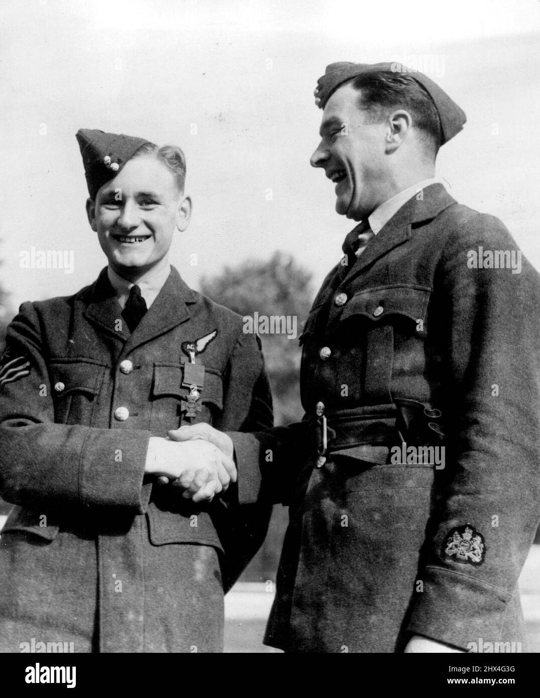 Sergeant Hannah Receives V.C. From The King: Sergeant John Hannah (left) congratulated by a Royal Air Force warrant officer as he left Buckingham Palace wearing the Victoria Cross. Sergeant John Hannah, 18-year-old air gunner of the Royal Air Force, went to Buckingham Palace to receive the Victoria Cross awarded him in recognition of the valour he displayed when he remained behind in a bomber to put out a fire instead of baling out. Sergeant Hannah came to London especially for the occasion. October 10, 1940. Stock Photo