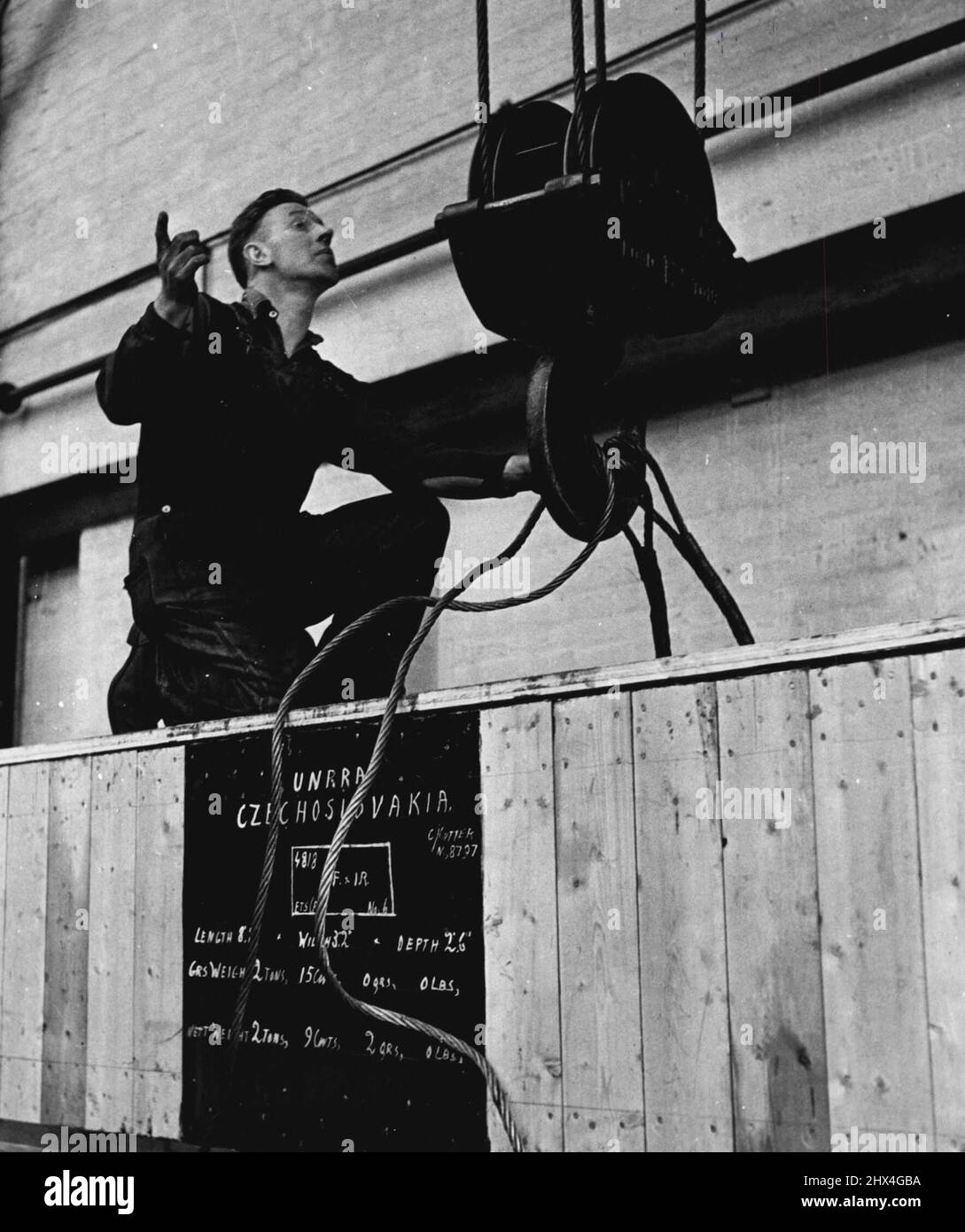 New Life In Heavy Industry -- Ready for shipment for Czechoslovakia is a crated coal cutter. Here it is being hoisted for despatch, a product of skilled men who work in healthy conditions in an atmosphere of harmony. September 03, 1951. (Photo by British Official Photograph). Stock Photo