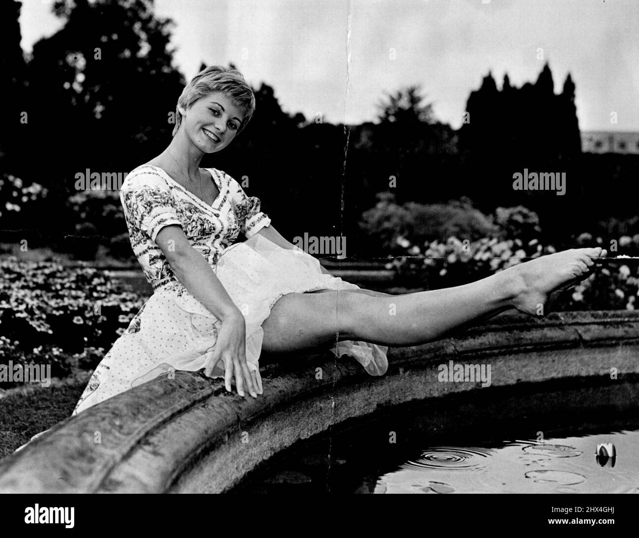 No Danger of this Jill falling down the Hill. She's 22-year-old Jill Ireland, cooling her toes by the lily pond at Pinewood Studios (England). Jill has just signed a contact to make a film, Simon and Laura. August 10, 1955. Stock Photo